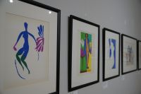 Henri Matisse. Papierowe poematy - barwne litografie wiszące na ścianie, przedstawiające wycinankowe prace artysty
