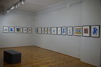 Papierowe poematy - barwne litografie wiszące na ścianie, przedstawiające wycinankowe prace artysty