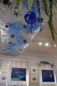 Fragment ekspozycji - widoczne plansze oraz aranżacja plastyczna przedstawiająca morze i ryby