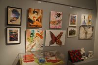 Fragment ekspozycji - widoczna gablota m.in. z serwetkami, na ścianach obrazy m.in.: malowane, haftowane, z suszonych kwiatów