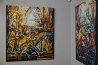 Fragment ekspozycji - widoczne dwa obrazy, w żywych, ciepłych kolorach, pełne dynamicznych linii, piramid, zygzaków