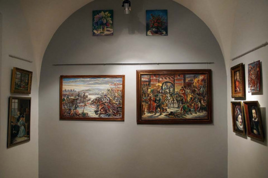 Fragment ekspozycji, na ścianie zawieszone obrazy przedstawiające sceny batalistyczne, portrety  oraz kwiaty