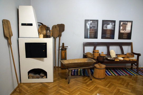 Fragment ekspozycji - piec chlebowy, dzieża, stępa, łopaty drewniane, ława na której ułożono wypieczone bochenki chleba