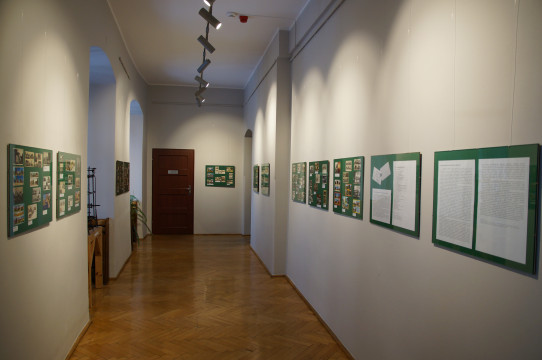 Fragment ekspozycji - widok ogólny sali, na ścianach powieszone plansze z pocztówkami