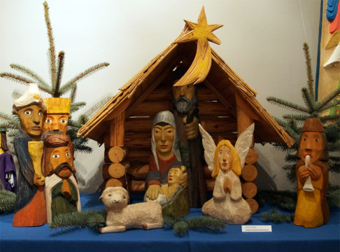 Fragment ekspozycji - drewniana szopka bożonarodzeniowa, na pierwszym planie figury: dzieciątko Jezus, Maria, Józef, trzej królowie, pastuszek i owieczka