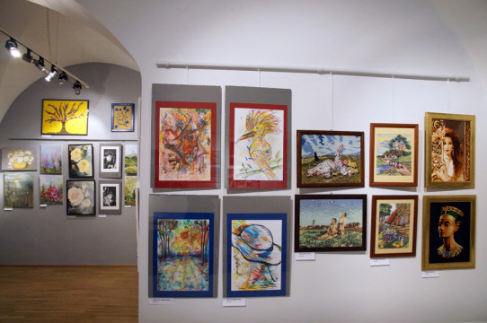 Fragment ekspozycji - na ścianie obrazy wykonane m.in. w technice rysunkowej, haftu krzyżykowego, z użyciem farby akrylowej. Dominują motywy kwiatowe, roślinne oraz portret i sceny rodzajowe. 